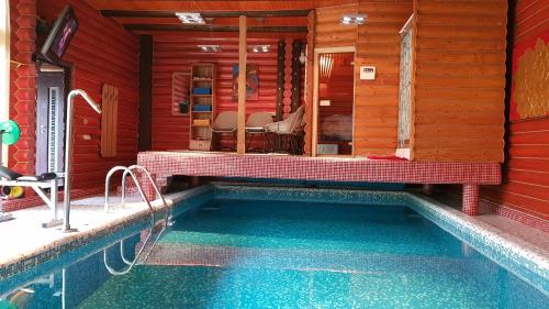 切尔诺夫策Luxury apartments with pool and sauna in the Villa的游泳池位于红色房子内,旁边设有长凳