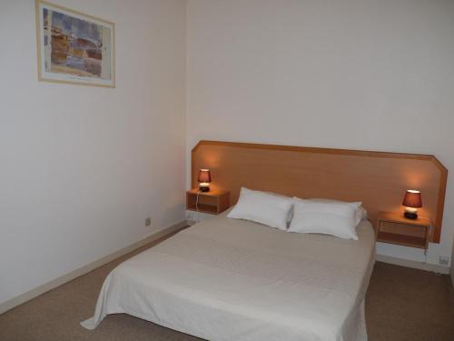 凯恩坦博罗杰斯纪念馆斯芬克斯酒店的一间卧室配有一张白色的床,两盏台灯放在两张桌子上