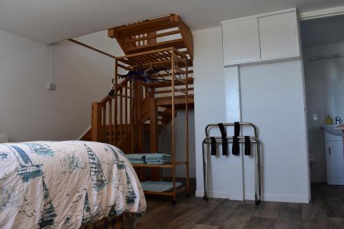 以撒港Plain Street Cottage, The Barn B&B的一间卧室设有一张床和木制楼梯。