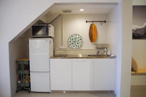 高冈市Travelers' house ROOTs的厨房配有白色冰箱和水槽