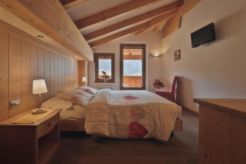 摩德纳迪-坎皮格里奥克里奇奥多洛米蒂酒店的一间卧室配有一张床、一张桌子和一个窗户。