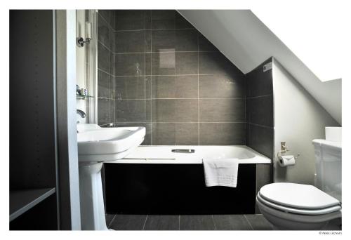 里尔德拉特尔伊酒店的一间带水槽、浴缸和卫生间的浴室