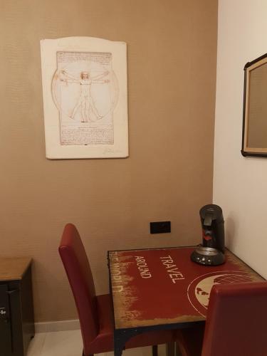坎布里尔斯Da Vinci Room VILLA BLANCA Cambrils的一张桌子和椅子,墙上挂着画