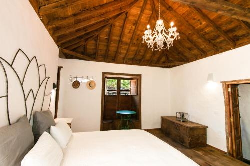 圣克鲁斯-德拉帕尔马Casa 1820 by Rural La Palma的卧室配有白色的床和吊灯。