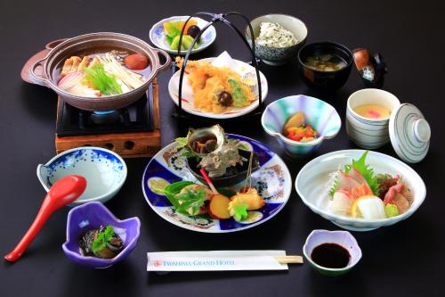 对马市Tsushima Grand Hotel的餐桌,盘子上放着食物和碗