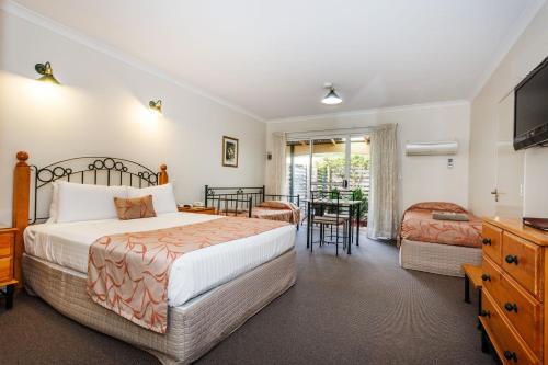 布里奇顿布里奇敦纳尔逊酒店的卧室配有一张床和一张桌子及椅子