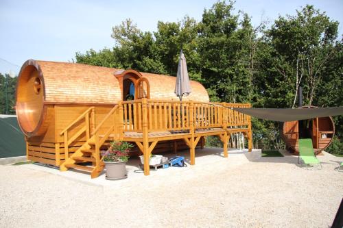 Dompierre-sur-MontL'Insolite Jurassienne的大型木屋设有甲板和遮阳伞