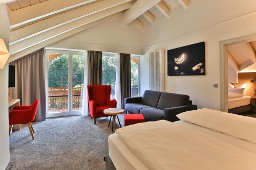 奥伯斯特多夫Elements Hotel Christlessee的酒店客房配有一张床、一张沙发和椅子。