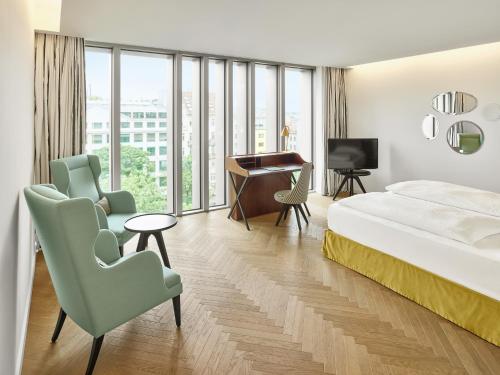 维也纳MAXX by Steigenberger Vienna的酒店客房,配有一张床、一张桌子和椅子