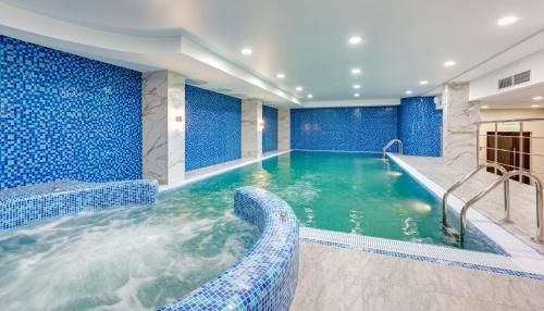 乌法巴施克瑞亚酒店的蓝色墙壁和游泳池的酒店游泳池