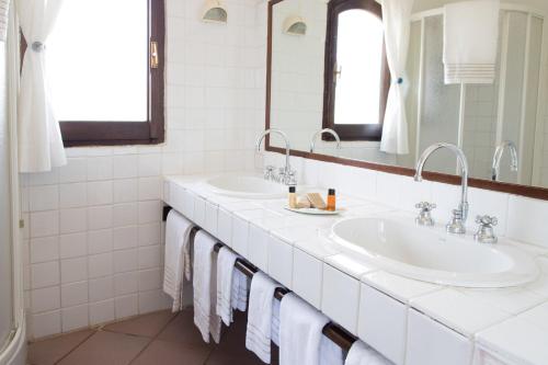 巴哈撒丁岛拉嘉恰度假酒店的白色的浴室设有两个盥洗盆和镜子