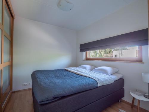 派尔努Pärnu Ranna Residents的一间卧室配有一张带蓝色毯子的床和窗户。
