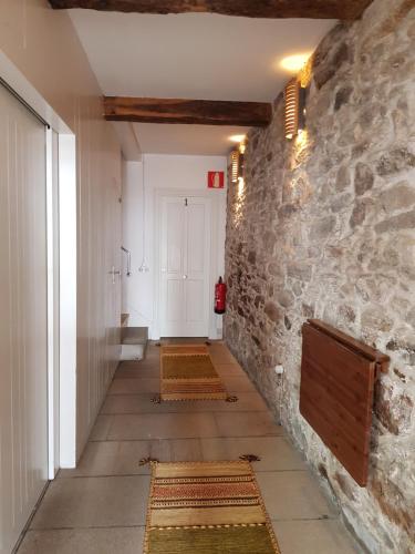 圣地亚哥－德孔波斯特拉迷人的圣马蒂诺旅馆的走廊上设有石墙,走廊上设有地毯