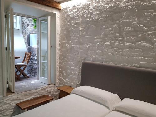圣地亚哥－德孔波斯特拉迷人的圣马蒂诺旅馆的一间卧室设有石墙和床