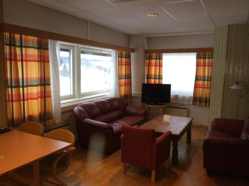 VormsundVormsund Golf Hotell的客厅配有皮革家具和桌子