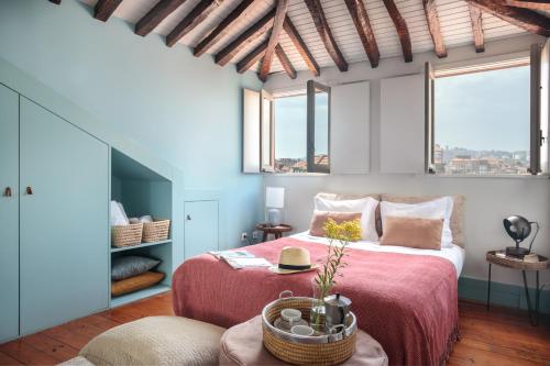 波尔图Own Places Clérigos Apartments的一间卧室配有一张红色床罩的床