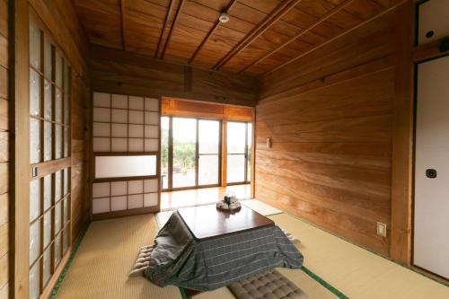 YudomariKumage-gun - House - Vacation STAY 89468的日式客房设有木墙和桌子。