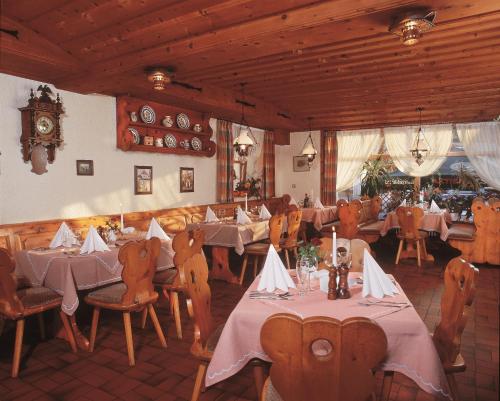 尼希施泰因盖斯特豪弗日尔弗酒店的餐厅设有桌椅和墙上的时钟
