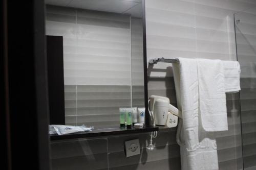 努瓦克肖特City Hôtel - Mauritanie的浴室设有镜子和架子上的毛巾