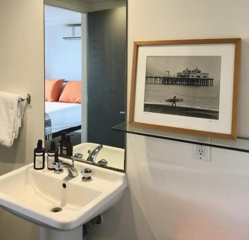 马里布马里布M汽车旅馆的浴室设有水槽,并画有码头的画面