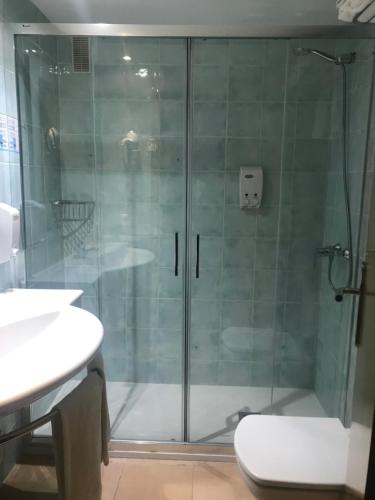 埃尔阿雷纳尔鸢尾花酒店的浴室里设有玻璃门淋浴