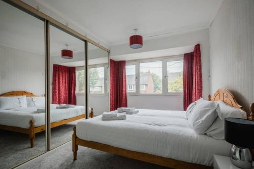 赫尔Hullidays - The Auckland House University Quarter的一间卧室设有两张床和大镜子