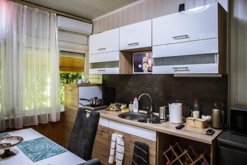 毛科Villa Apartman的厨房配有白色橱柜和水槽