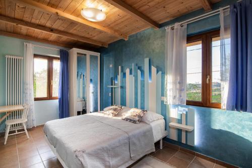 格拉达拉La Casa Del Sole的一间卧室配有一张蓝色墙壁和窗户的床
