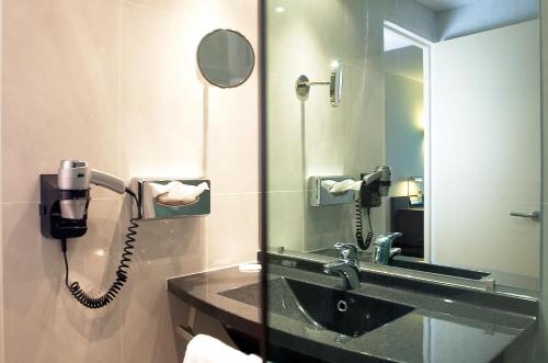 坎佩尔坎佩尔大洋洲酒店的浴室设有水槽旁的电话