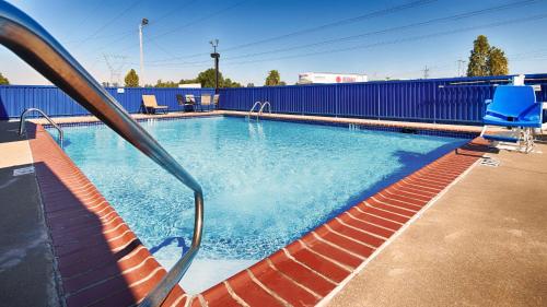 帕迪尤卡帕迪尤卡贝斯特韦斯特酒店的一个带蓝色栅栏和蓝色椅子的游泳池