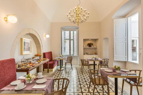 普蒂尼亚诺Dimora Clementina的一间带桌椅和吊灯的餐厅