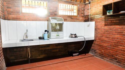 三宝垄Villa Karang Kedempel Bandungan SimplyHomy的砖墙内带水槽的厨房