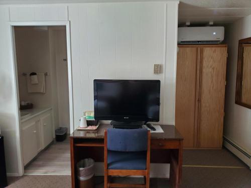 Delta JunctionAlaska Country Inn的一间配备有书桌的客房,配备有一台电视。