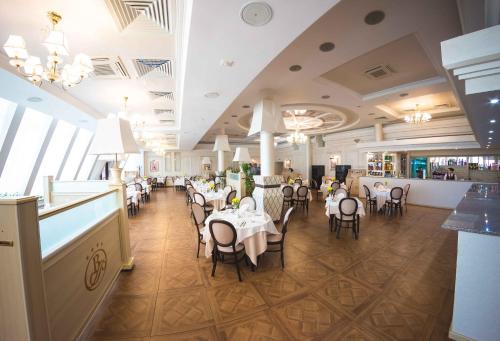 斯捷尔利塔马克Grand Hotel Vostok的餐厅内带桌椅的用餐室