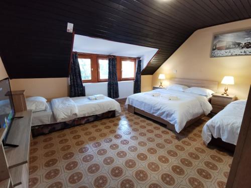 久洛Ambient Deluxe Apartman的酒店客房设有两张床和窗户。