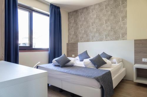 阿科Arco Smart Hotel的一间卧室配有白色床和蓝色枕头