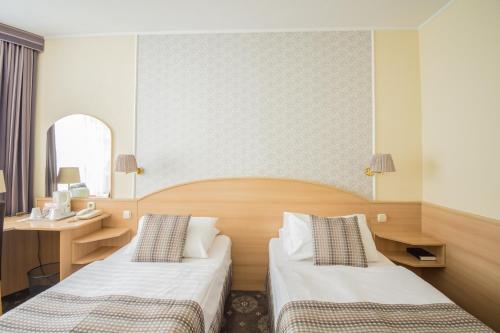 布达佩斯猎户座城堡花园酒店的酒店客房,设有两张床和镜子