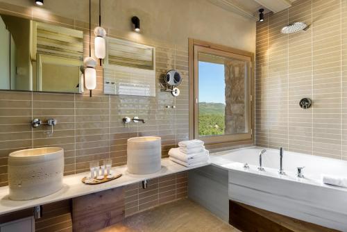 蒙罗约Torre del Marqués Hotel Spa & Winery - Small Luxury Hotels的带浴缸、水槽和镜子的浴室