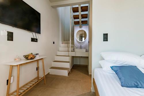 林都斯Lindos Calmare Suites的一间卧室配有一张床,楼梯配有镜子