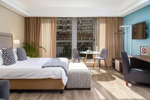 开普敦WINK Aparthotel Foreshore的卧室配有一张床和一张桌子及椅子