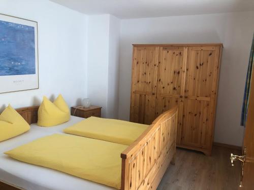 贝希特斯加登奥伯劳菲丽瓦汉京酒店的一间卧室设有两张床和木制橱柜