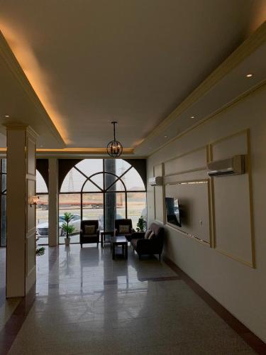 Al ḨawīyahRadiha Hotel Suites的大楼内客厅配有沙发和椅子