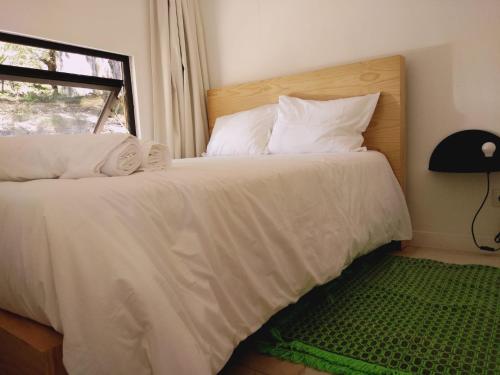 蒙塔莱格里Ninho da Avó Selvagem的一间卧室配有一张带白色床单的床和一扇窗户。