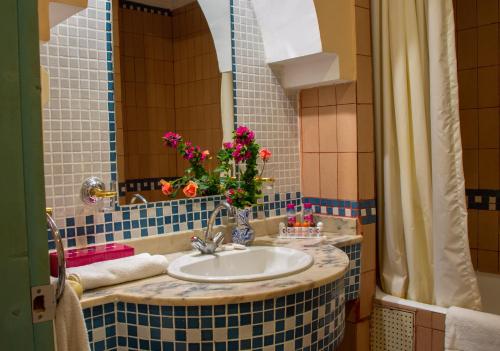 Afourer彻斯勒塔扎库特酒店的浴室内装有鲜花的水槽