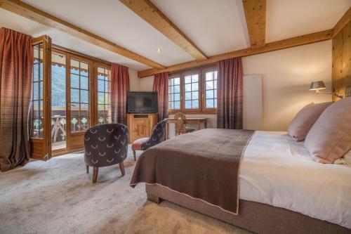 夏蒙尼-勃朗峰奥贝奇酒店的一间卧室配有一张大床和电视