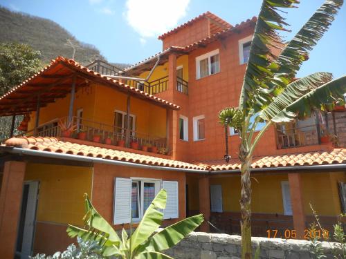 PaulPousada do Ceu的一座橘色房子,前面有一棵棕榈树