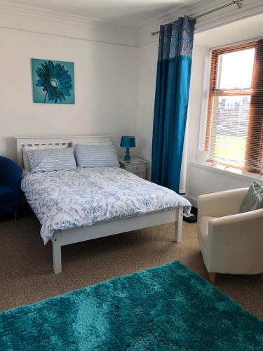 勒威克Rockvilla Guest House的一间卧室配有一张带蓝色窗帘的床和一张沙发