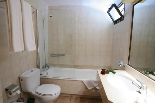 塔乌里托Hotel LIVVO Lago Taurito & Aquapark的浴室配有卫生间、浴缸和水槽。