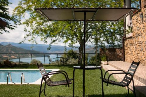Sant Marti de CanalsCasa Boumort的游泳池旁遮阳伞下的桌椅