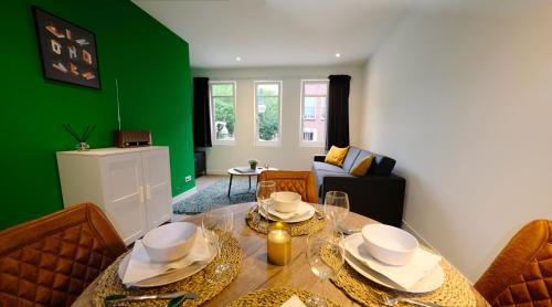 埃因霍温Luxury 60m2 Apartment with 20m2 Private Terrace的一间设有桌子和绿色墙壁的用餐室